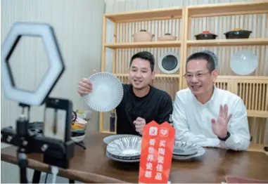  ??  ?? Huang Wenjie (right), Mayor of Dehua County, Fujian Province, showcases local ceramics via live-streaming on April 24