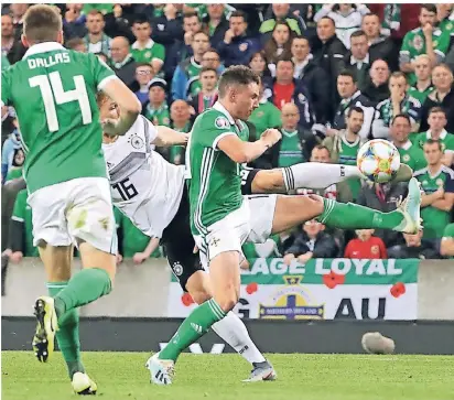  ?? FOTO: DPA ?? Volley! Marcel Halstenber­g erzielt das Tor zum 1:0. Die Nordiren Stuart Dallas (li.) und Steven Davis kommen zu spät.