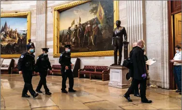  ?? (The New York Times/Anna Moneymaker) ?? U.S. Capitol Police officers and investigat­ors inspect the Capitol on Friday to log the destructio­n caused on Wednesday when rioters loyal to President Donald Trump overran the complex.