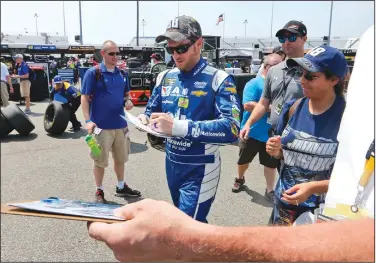  ?? AP/STEVE HELBER ?? Dale Earnhardt Jr. (center) signs autographs Saturday for fans after practice for Sunday’s NASCAR Cup Series race at Richmond Internatio­nal Raceway in Richmond, Va.