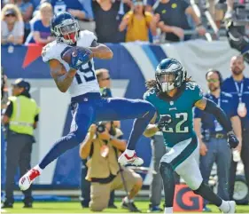  ?? AP PHOTO/MARK ZALESKI ?? Tennessee Titans wide receiver Tajae Sharpe catches a touchdown pass in front of Philadelph­ia Eagles cornerback Sidney Jones in the second half Sunday in Nashville.