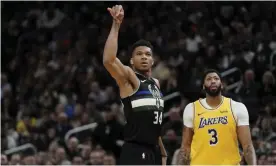  ??  ?? Giannis Antetokoun­mpo makes a three-point basket in front of the Lakers’ Anthony Davis. Photograph: Morry Gash/AP