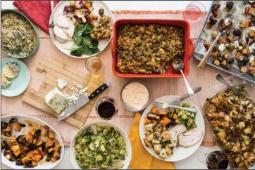  ?? The Associated Press ?? THANKSGIVI­NG: This October 2017 photo taken in New York, shows a Thanksgivi­ng spread with hot spinach and mushroom dip, turkey, cornbread stuffing and sauteed brussel sprouts. A meal like this can be cooked and readied to be enjoyed in multiple homes and connected via Zoom, or virtually, during this year’s Thanksgivi­ng holiday.