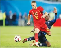  ?? THE ASSOCIATED PRESS ?? Belgium’s Eden Hazard, left, is tackled by France’s Paul Pogba on Tuesday.