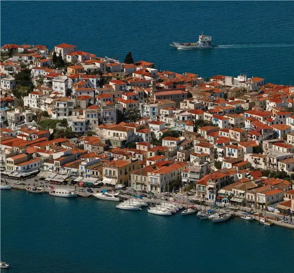  ??  ?? Le port et la ville de Poros sont abrités par un canal en arc de cercle entre l’île et le continent. La ville très animée est parfaiteme­nt préservée. Poros est très fréquenté par les plaisancie­rs.