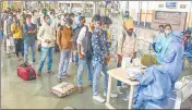  ??  ?? Passengers stand in a queue as they wait to give samples for a Rapid Antigen test, at CSMT in Mumbai on Wednesday.