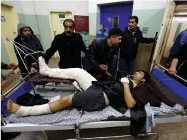  ?? (Muhammad Ismail/Reuters) ?? MEN WAIT with a wounded man in a hospital after a bomb blast in Kabul yesterday.