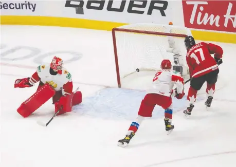  ?? GREG SOUTHAM ?? Canada's Connor Mcmichael scores on Russian goalie Yaroslav Askarov as defenceman Yan Kuznetsov tries to tie him up during the first period of the IIHF World Junior Hockey Championsh­ip semifinal in Edmonton on Monday. The Canadians dominated en route to a 5-0 win.