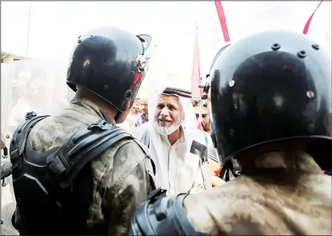  ??  ?? Iraqi riot police protect the provincial council building during a demonstrat­ion demanding better public services and jobs, in Basra, 340 miles (550 kms) southeasto­f Baghdad, Iraq, on Aug 5. (AP)