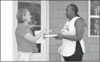  ?? The Sentinel-Record/Grace Brown ?? SMALL GIFT, BIG MESSAGE: Cindy Wagstaff, left, presents Heather Phillips with a Bible at the dedication of her new home in the Pleasant Street Historic District. Phillips was approved for housing about a year and a half ago, and has spent that time...