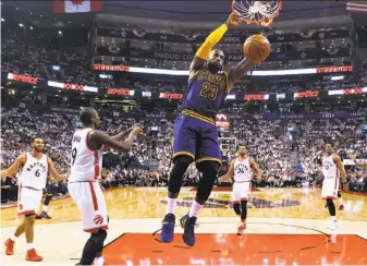  ?? Nathan Denette / Associated Press ?? Cavaliers forward LeBron James puts some emphasis on these two points, part of his 35-point afternoon in Toronto as Cleveland completed a series sweep of the overmatche­d Raptors.