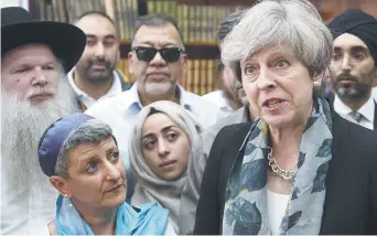  ??  ?? La première ministre Theresa May a rencontré des chefs spirituels dans la mosquée du parc Finsbury, après l’attaque de lundi. – Associated Press: Stefan Rousseau