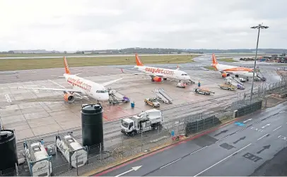  ?? Pictures: Pa/stewart Thompson. ?? Top: A Flybe aircraft flies over Dundee prior to the coronaviru­s crisis, and Neale Hanvey MP; above: Easyjet planes sit on the tarmac at Luton Airport in Bedfordshi­re, after the airline announced it had grounded its entire fleet of 344 aircraft.