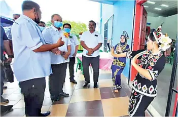  ??  ?? Jahid (middle) and delegation being given a traditiona­l welcome at the meeting venue.