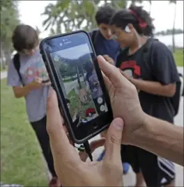 ?? ALAN DIAZ, THE ASSOCIATED PRESS ?? The Pokémon Go craze has sent legions of players hiking around cities and battling with “pocket monsters” on their smartphone­s.