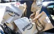  ?? THE ASSOCIATED PRESS ?? Amazon Prime Now bags full of groceries are loaded for delivery by a part-time worker outside a Whole Foods store in Cincinnati.