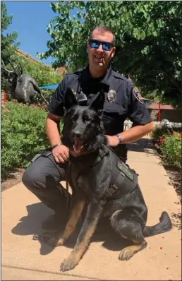  ?? COURTESY PHOTOGRAPH ?? Kane wears his new ballistics vest while sitting next to Galt Police K9 Officer Mike Little.