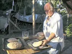  ??  ?? Ed Tutino prepares his soldier’s bread dough before placing it into his beehive oven.