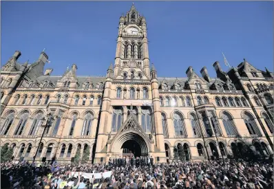  ??  ?? Mourners attend a vigil outside the town hall for the 22 people killed in Monday’s terror attack on the Manchester Arena. UK security was put on high alert.