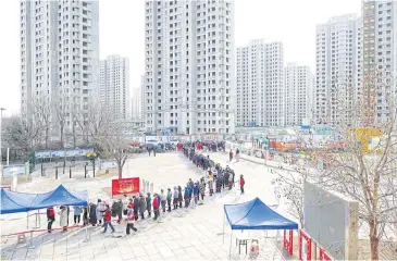  ?? REUTERS ?? Tianjin residents line up for Covid-19 testing during a citywide mass testing drive yesterday, after local cases of the Omicron variant were detected.