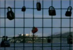  ?? AP PHOTO/JEFF CHIU ?? Alcatraz Island is shown behind a locks on a pier fence in San Francisco on Saturday. A partial federal shutdown has been put in motion because of gridlock in Congress over funding for President Donald Trump’s Mexican border wall. The company that provides ferry services to Alcatraz Island kept its daytime tours but canceled its behind-thescenes and night tours for Saturday.