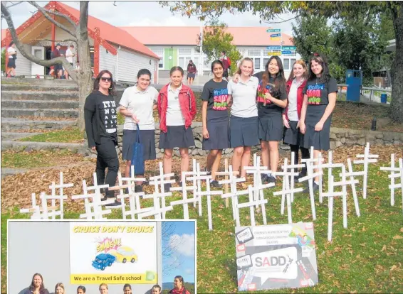  ??  ?? Members of Te Puke High School’s SADD committee with the crosses put up in the school grounds representi­ng dangerous driving deaths.