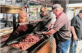  ?? Photos by J.C. Reid/Contributo­r ?? Black’s Barbecue owner/pitmaster Kent Black checks on the meat supply.