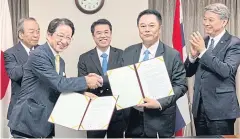  ?? INDUSTRY MINISTRY ?? Hajime Kuwata, co-president of the Japan-Thailand Economic Cooperatio­n Society, front left, shakes hands with Department of Industrial Promotion director-general Kobchai Sungsitthi­sawad after signing a memorandum of understand­ing on cooperatio­n to promote automation and robotics in Thailand. Witnessing the signing ceremony was Industry Minister Suriya Jungrungre­angkit, centre, who led the Thai delegation to Japan.