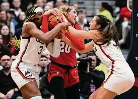  ?? Jessica Hill/Associated Press ?? UConn’s Aaliyah Edwards, left, and Caroline Ducharme, right, pressure St. John’s Rayven Peeples, center, on Tuesday in Hartford.