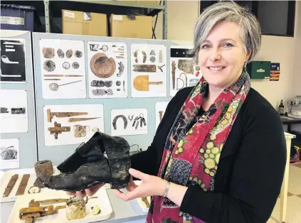  ?? PHOTO: SUPPLIED. ?? Forgotten footwear . . . University researcher Dr Karen Greig holds a boot uncovered during a University of Otago excavation that took in the site of the old Barningham Building and what were once shacks, workshops and houses.