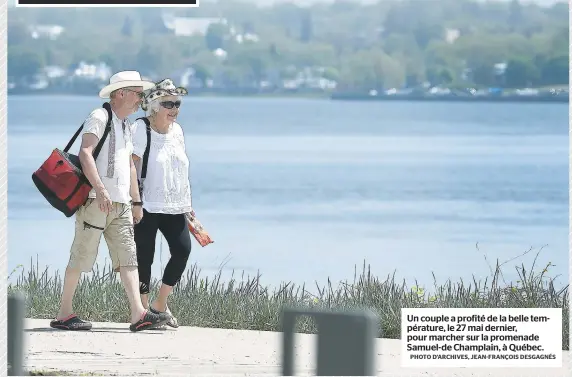  ?? PHOTO D’ARCHIVES, JEAN-FRANÇOIS DESGAGNÉS ?? Un couple a profité de la belle températur­e, le 27 mai dernier, pour marcher sur la promenade Samuel-de Champlain, à Québec.