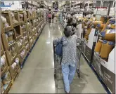  ?? DAVID ZALUBOWSKI THE ASSOCIATED PRESS ?? Shoppers look over blankets on sale in a Costco warehouse in August. The U.S. economy expanded at a robust 4.9% annual rate.