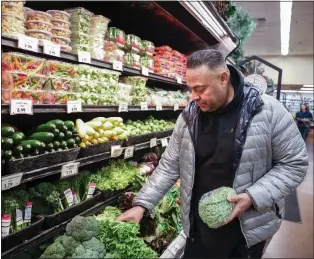  ?? SHAE HAMMOND — STAFF PHOTOGRAPH­ER ?? Lorberto Macias, of San Jose, a produce manager at Zanotto's Family Market, arranges lettuce in the store in San Jose on Dec. 14.