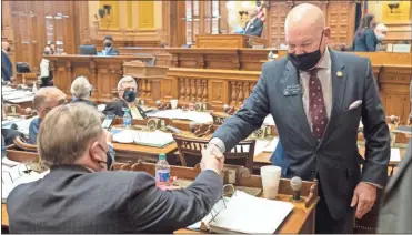  ?? AP-Ben Gray ?? Georgia State Sen. Mike Dugan (R-Carrollton) shakes hands with Rules Committee Chairman Sen. Jeff Mullis (R-Chickamaug­a) after the passage of Senate Bill 241, which changes Georgia’s voting laws, Monday at the State Capitol in Atlanta. Dugan presented the bill.