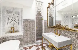  ??  ?? A 19th Century Venetian mirror hangs above a marble vanity in this spa bathroom.