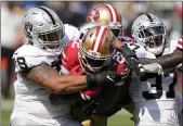  ?? TONY AVELAR – THE ASSOCIATED PRESS ?? San Francisco 49ers running back Wayne Gallman II, middle, runs between Las Vegas Raiders nose tackle Niles Scott, left, and safety Tyree Gillespie during the second half in Santa Clara on Sunday.