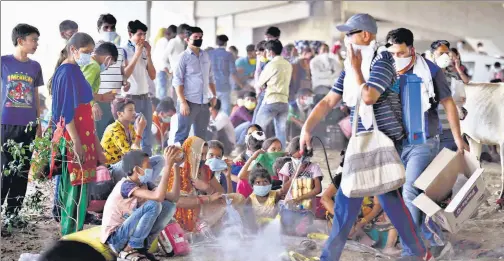  ?? ARVIND YADAV/HT PHOTO ?? Stranded migrant workers gathered under a flyover at the Ghazipur border on Sunday. n