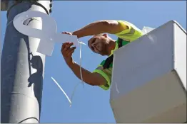  ?? Katharine Lotze/The
Signal ?? Michael Doroginsky, a street maintenanc­e worker with the city, hangs a white ribbon at the intersecti­on of Valencia Boulevard and Citrus Street on Tuesday.