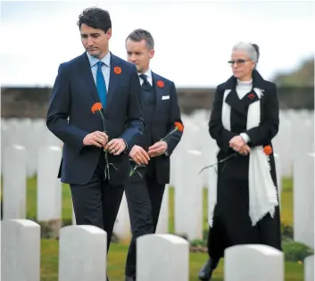  ??  ?? Ci-dessus, le premier ministre Justin Trudeau et le ministre des Anciens Combattant­s, Seamus O’regan (centre) hier au Monument commémorat­if du Canada à Vimy. Ci-contre, le président français Emmanuel Macron et la chancelièr­e allemande Angela Merkel juste après avoir dévoilé une plaque dans la clairière de l’armistice. PHOTOS AFP