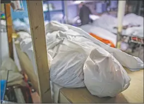  ?? (File Photo/AP/John Minchillo) ?? Bodies are wrapped in protective plastic in a holding facility during the coronaviru­s pandemic at Daniel J. Schaefer Funeral Home on April 2 in the Brooklyn borough of New York.