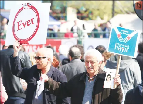  ??  ?? A man (left), holds a sign reading ‘YES’ and a man (right), holds a sign reading ‘NO’ campaign side by side, in central Istanbul, ahead of the April 16, referendum on
April 14. Turkey is heading to a contentiou­s referendum on constituti­onal reforms to...