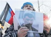  ??  ?? NOT FORGOTTEN: A woman holds a photo of Russian opposition politician Boris Nemtsov during a rally marking the 5th anniversar­y of his death, in Saint Petersburg.