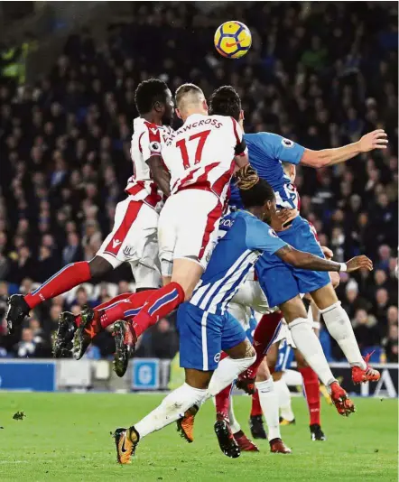  ??  ?? Heads up: Stoke’s Ryan Shawcross (top centre) heading towards goal during the English Premier League match at the Amex Stadium in Brighton on Monday.