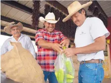  ?? ROBERTO E. ROSALES/JOURNAL ?? Reymundo Aparicio, left, along with Sergio Grajeda, center, sells green chile to Pedro Verdugo on Wednesday at the Hatch Chile Market.