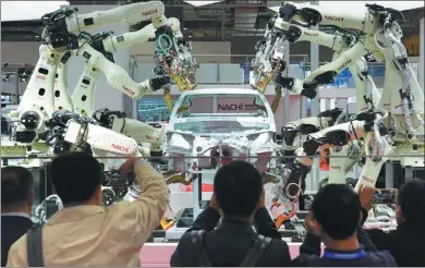  ?? GAO ERQIANG / CHINA DAILY ?? Robots assembling a car draw visitors to Japanese corporatio­n Nachi-Fujikoshi’s exhibition area during the China Internatio­nal Import Expo on Monday.