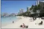  ?? CALEB JONES — THE ASSOCIATED PRESS ?? People relax on the beach in Waikiki in Honolulu. Half of Americans polled can’t afford a vacation this year.