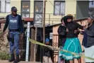  ?? Ihsaan Haffejee/AFP/Getty Images ?? A relative of one of the victims is consoled as South African police officers refuse to let her cross the police barrier. Photograph: