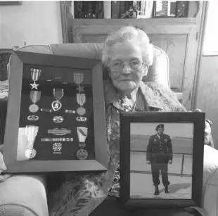  ??  ?? Oleta Smith of Dumas, Texas, 97, the oldest Gold Star mother in Texas, has found solace from three men who were in Vietnam with her son, Sgt. Warren Smith. Smith holds her son’s picture and display of his war medals Thursday.