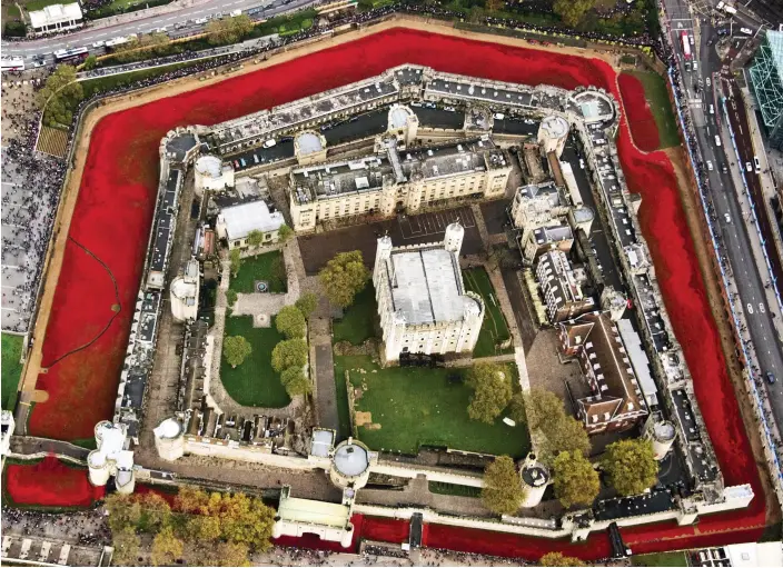  ??  ?? The Tower surrounded: In a spectacula­r aerial image, the sea of red poppies encircles the Tower of London yesterday. Thousands flocked to pay tribute to Britain’s war dead on Remembranc­e Sunday, falling silent and hushed at 11am