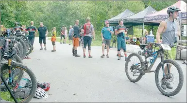  ?? Keith Bryant/The Weekly Vista ?? Racers take a break at roughly the midpoint of the course, grabbing food and drink before heading back into the trails.